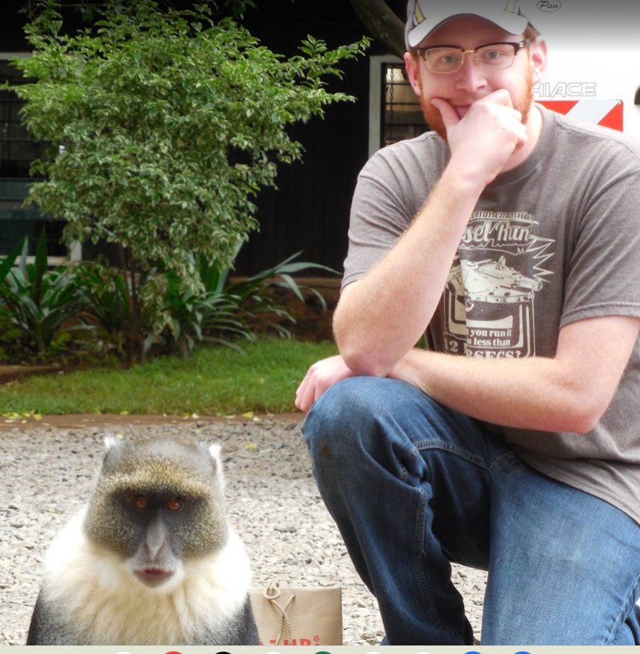 A younger Kayson crouching a short distance behind a Sykes' guenon in Kenya
